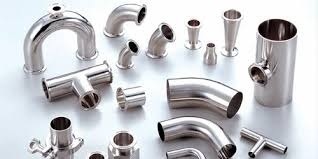 A variety of polished stainless steel sanitary pipe fittings, including elbows, tees, reducers, and clamps for food and pharma processing.